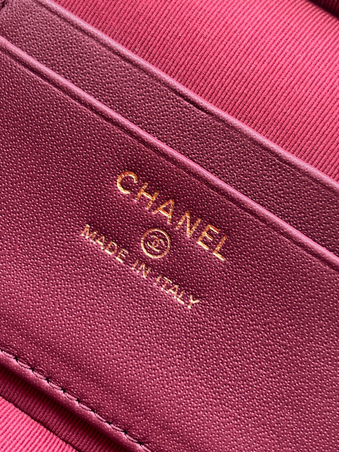 Chanel logo on burgundy leather strap with embossed text and stitching