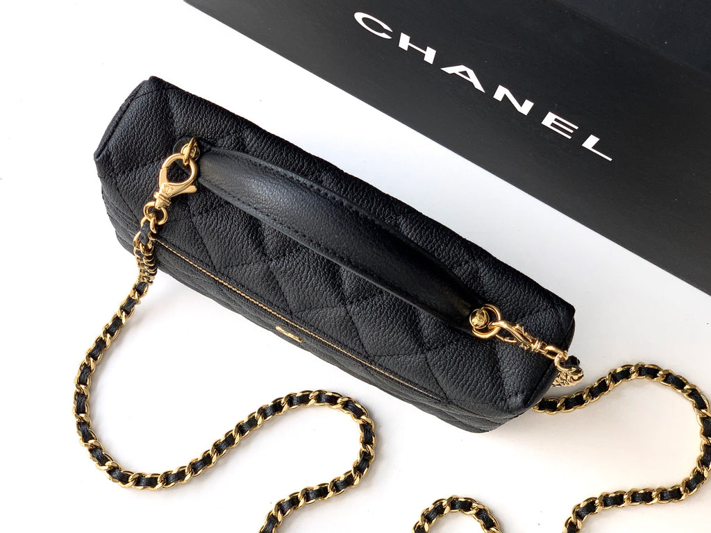 Black quilted crossbody bag with gold chain strap and gold zipper trim.