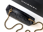 Black quilted crossbody bag with gold chain strap and gold zipper trim.