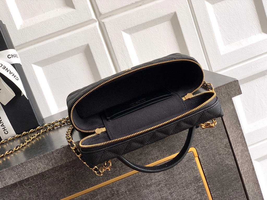 Black quilted handbag with zip-top opening and gold chain strap.