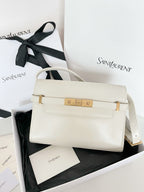 Cream leather handbag with gold clasp and shoulder strap, front flap closed