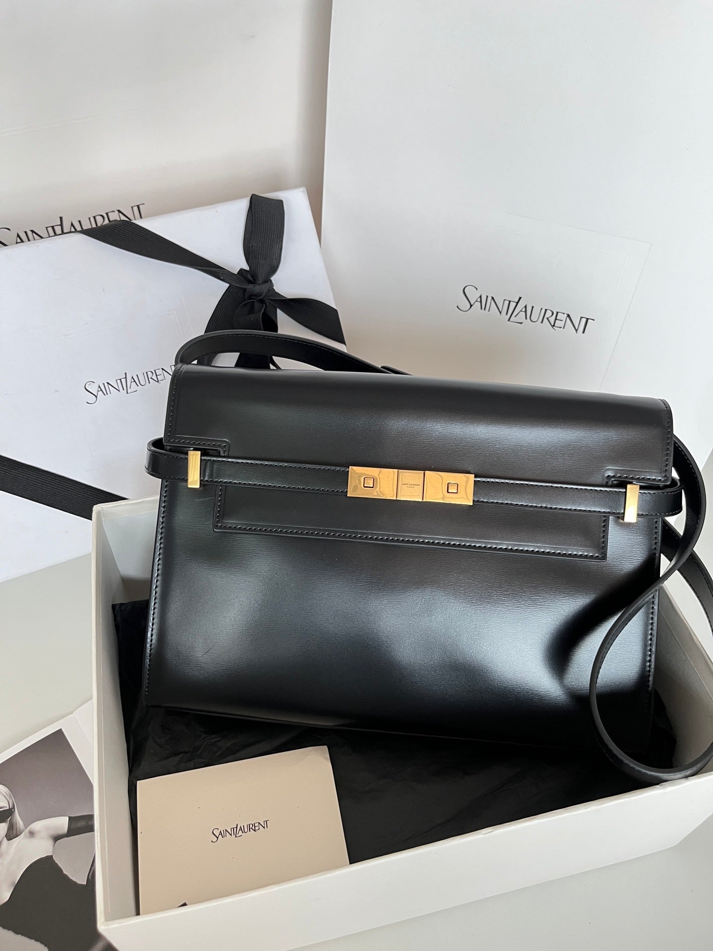 YSL handbag in dark leather with gold-tone front hardware and top handle
