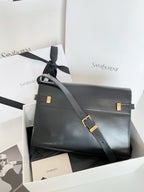 YSL handbag in dark leather with shoulder strap and gold-tone buckle hardware