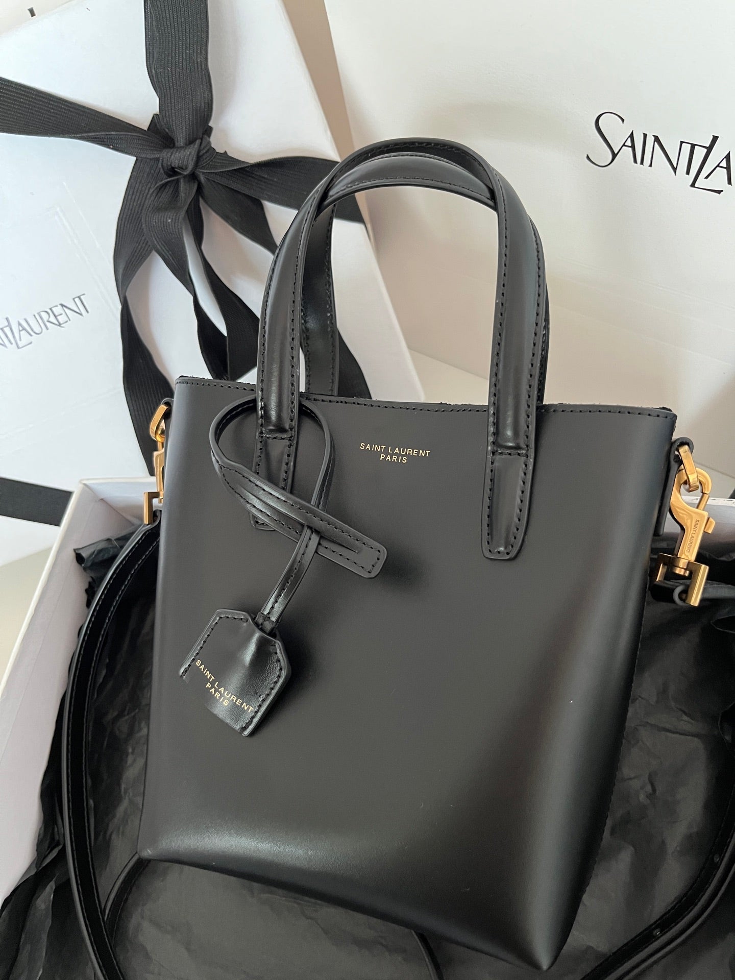 YSL dark gray leather tote bag with top handles and hanging charm tag