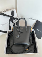 YSL dark gray leather tote bag with top handles, bow charm, and gold hardware