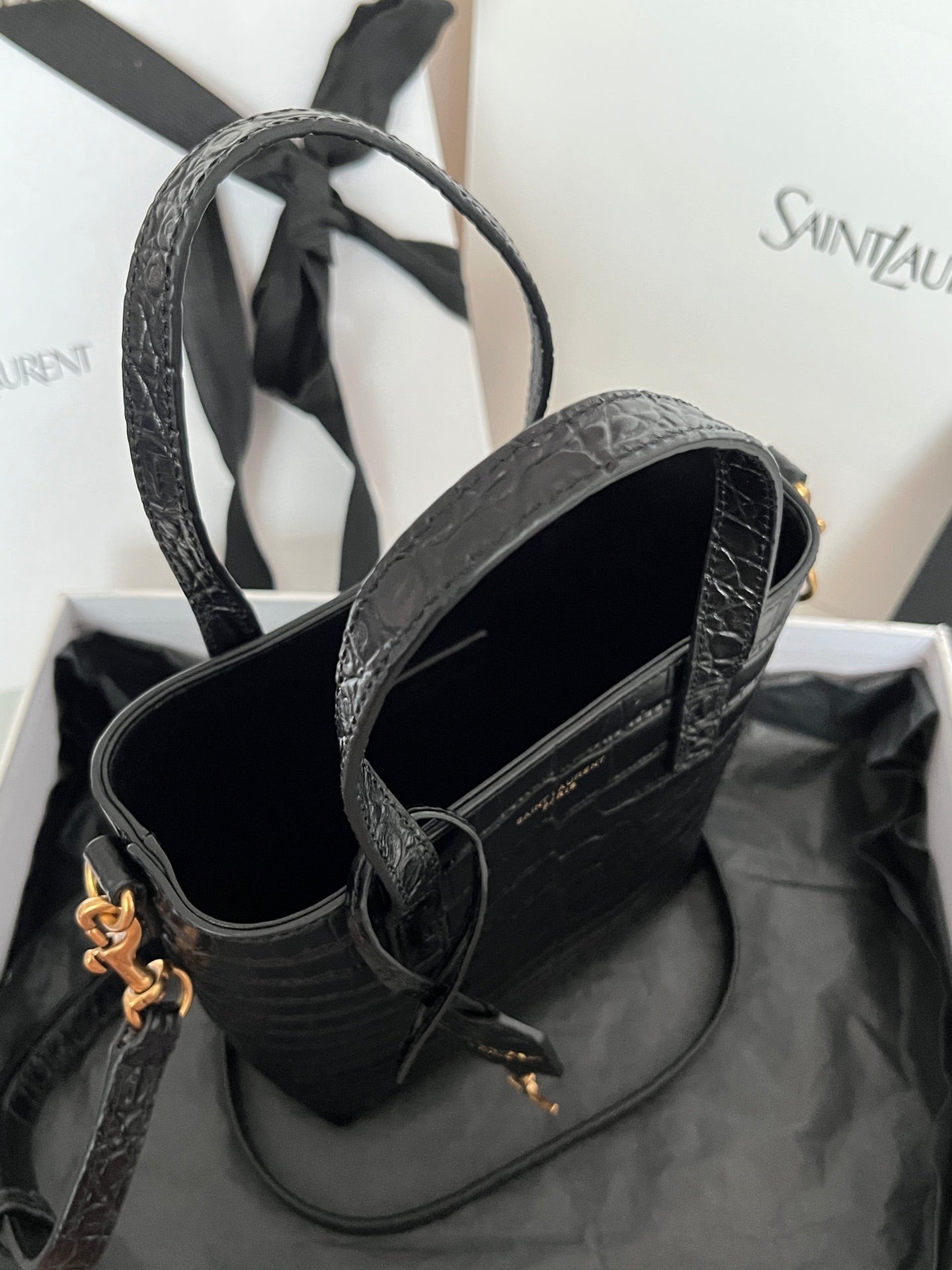 Black croc-embossed leather tote bag interior view with top handles and gold hardware