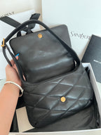 Quilted dark leather tote-style bag with top handles and gold logo button on front