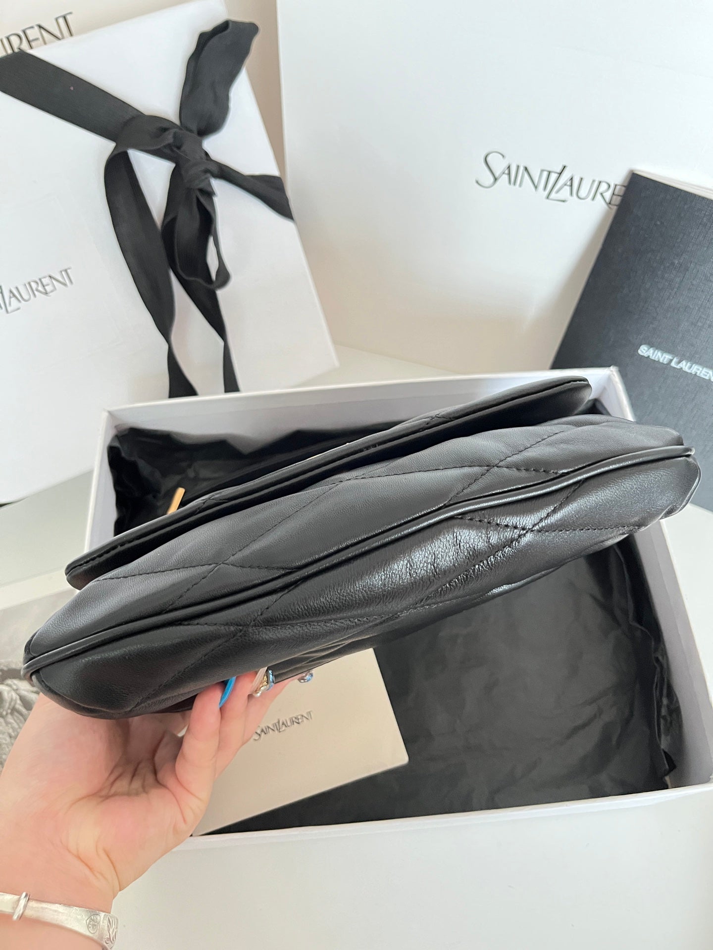 Quilted dark leather shoulder bag with long strap and smooth top edge