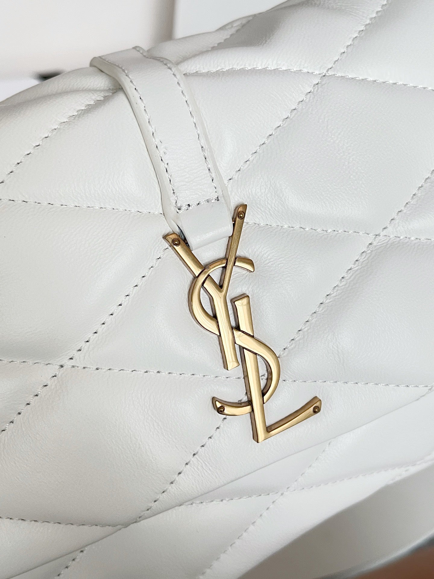 YSL quilted mini handbag, white, close-up of gold YSL logo hardware