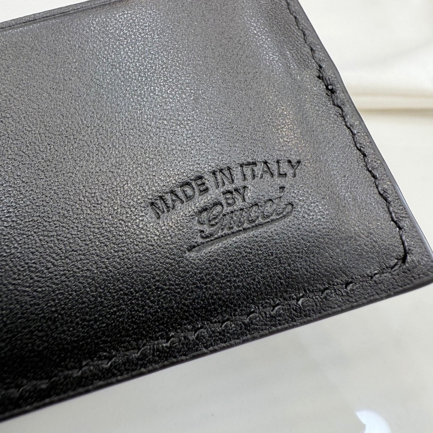 Gucci leather wallet stamp detail reading "MADE IN ITALY".