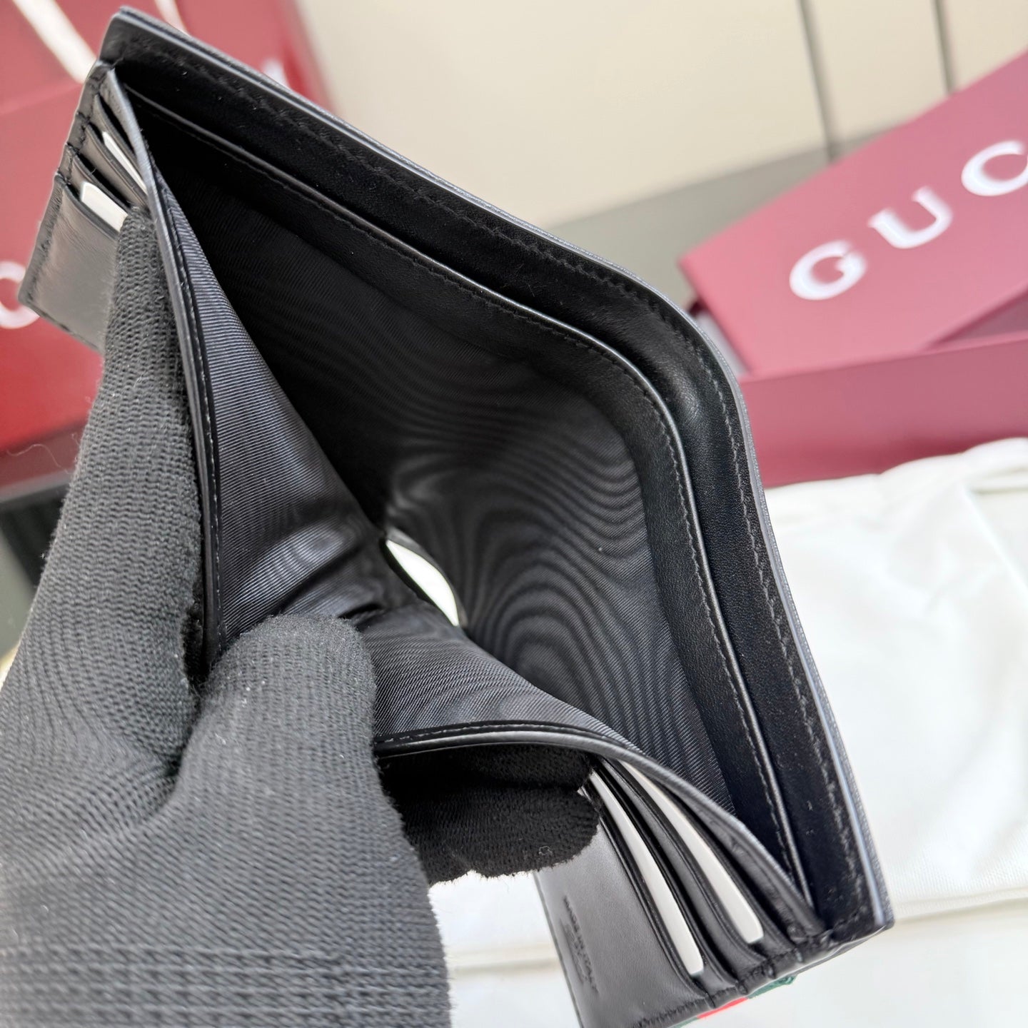 Gucci small leather wallet interior view, black lining and card slots.