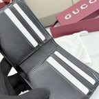 Gucci small leather wallet close-up of card slots with striped accents.
