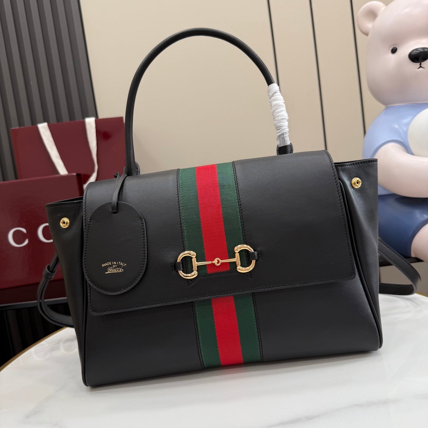 Black leather Gucci tote bag with green and red web stripe, gold-tone hardware