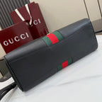 Black leather Gucci bag with green and red web stripe on top flap