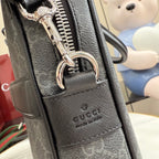 Gucci bag closeup: dark textured leather front, logo panel, metal zipper pull