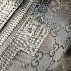 Close-up of GG monogram leather with embossed logo pattern and stitched trim.