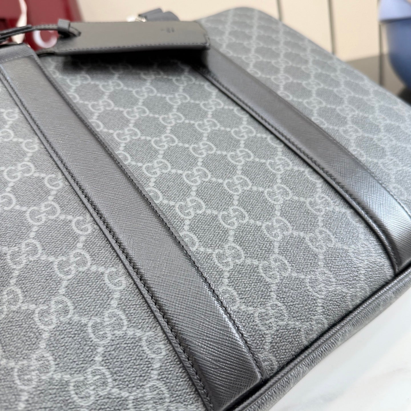 GG monogram bag interior panel with dark leather piping and stitched edge.