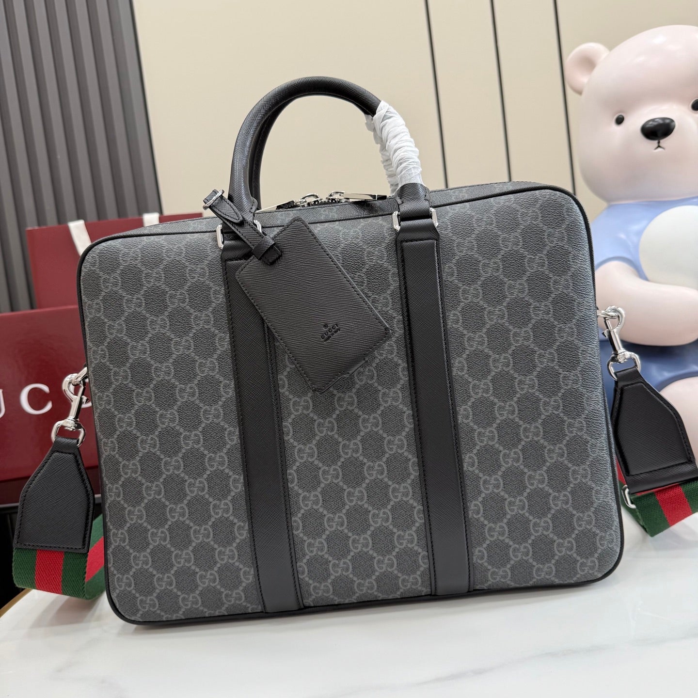 GG monogram top-handle bag with dark leather trim and front pocket detail.