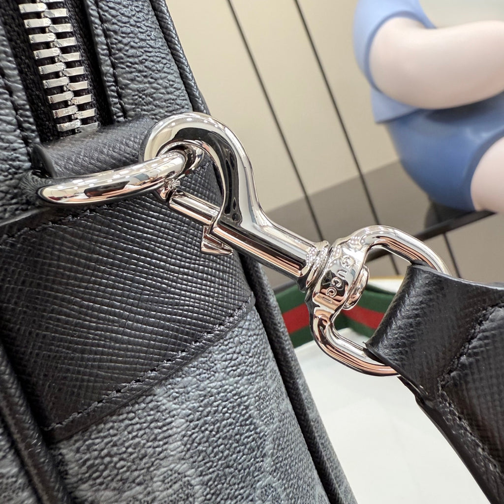 Gucci bag closeup: polished metal D-ring clip and textured dark leather strap