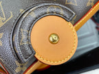 Tan leather snap tab with round gold button on monogram handbag strap