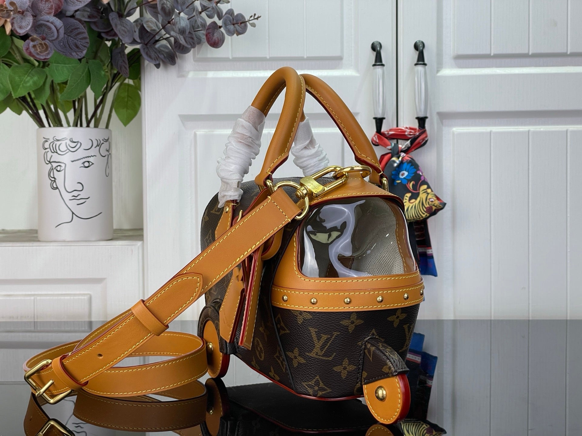 Louis Vuitton monogram handbag with tan strap, front opening, and gold trim detail