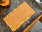 Tan leather nameplate with embossed Louis Vuitton text on monogram canvas bag
