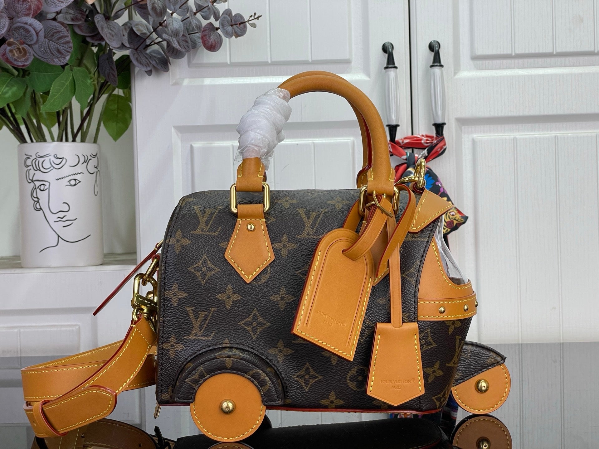 Louis Vuitton monogram handbag with tan leather handles, straps, and gold hardware