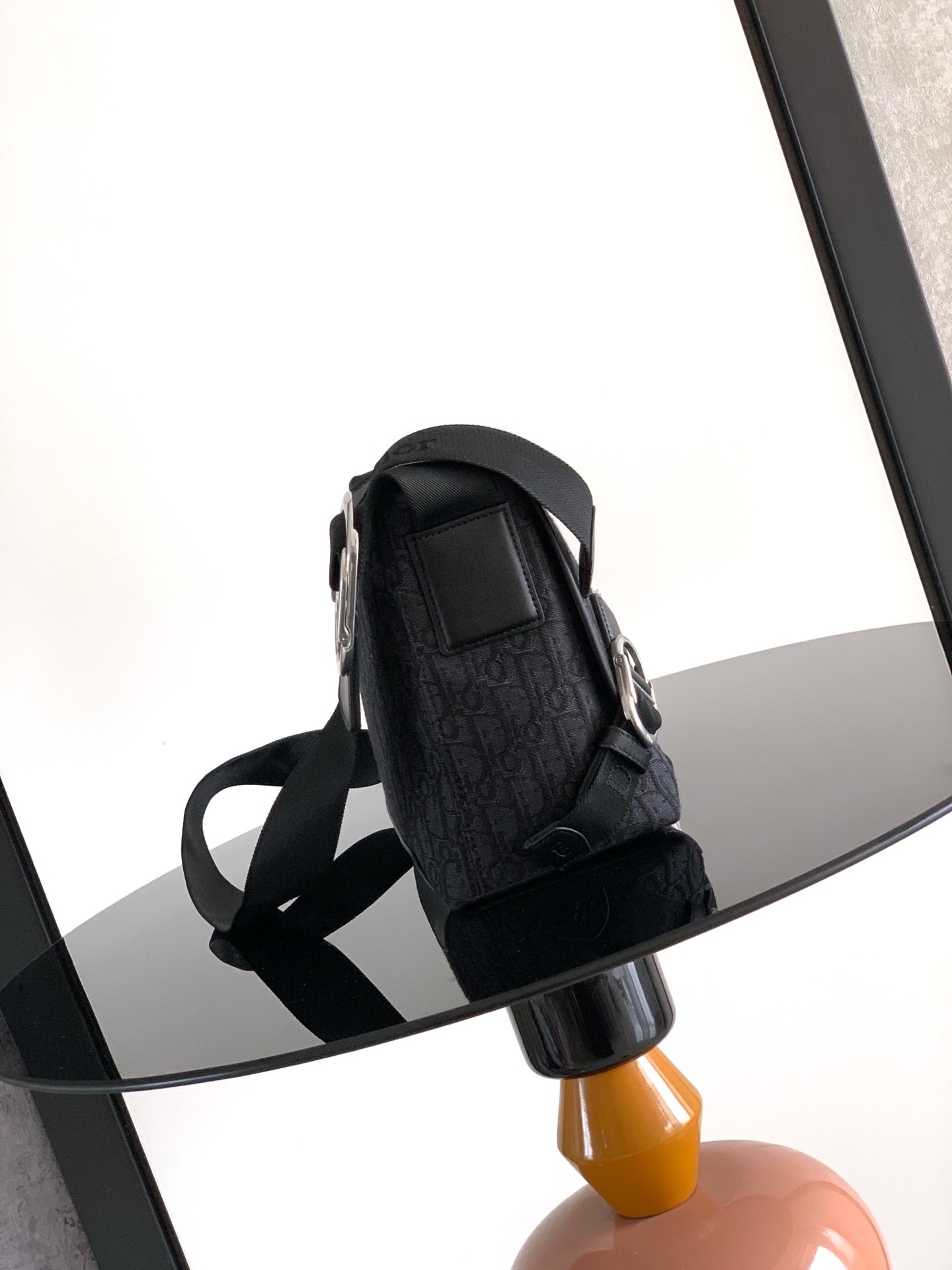 Dior crossbody bag with textured dark exterior and adjustable shoulder strap