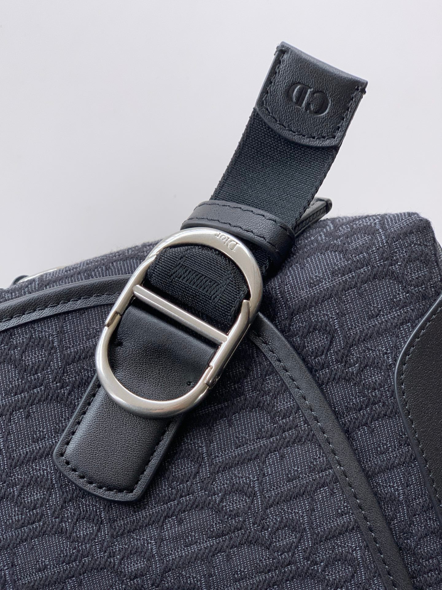 Dior logo strap loop with silver buckle on patterned bag