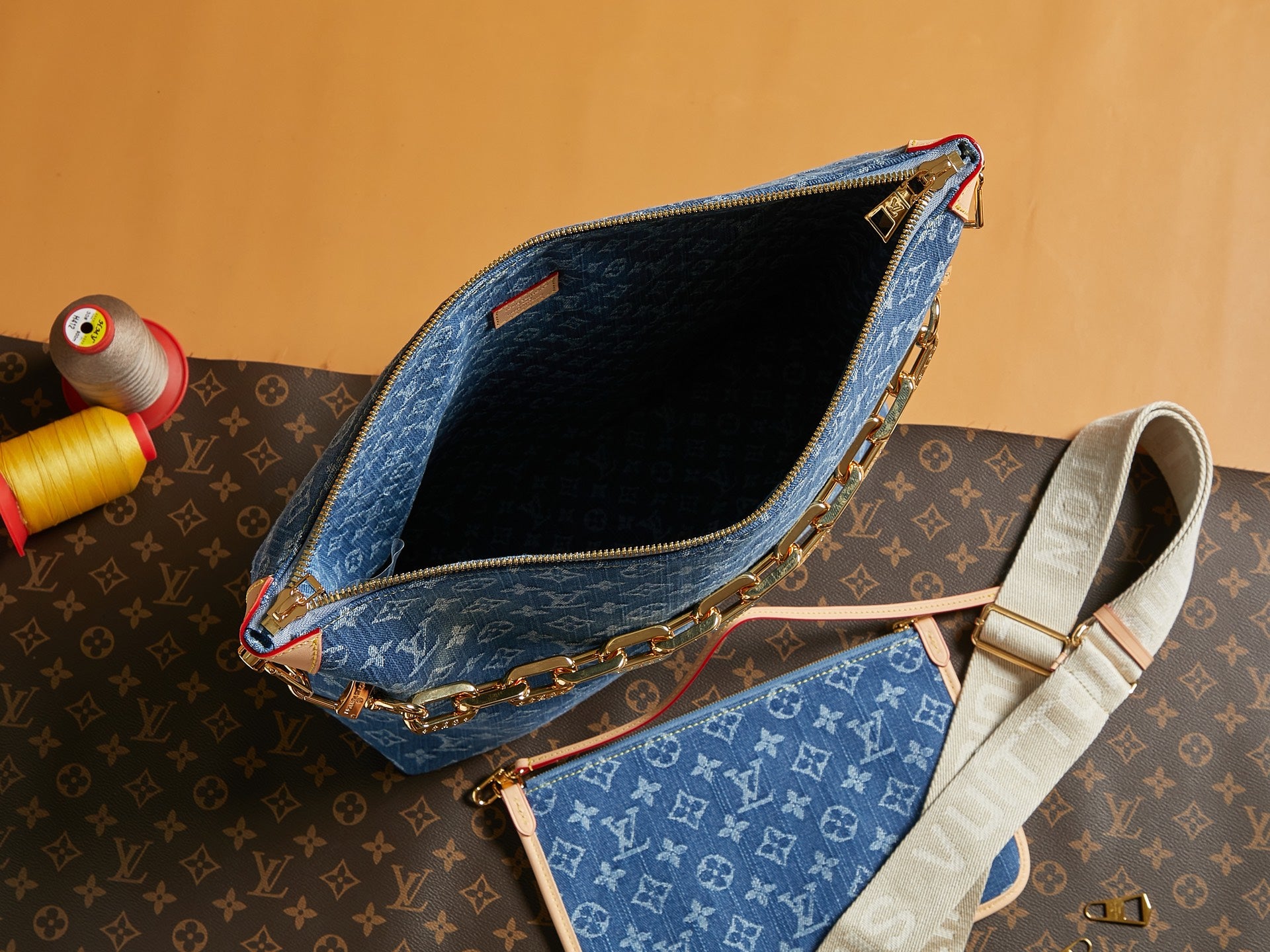 Open blue monogram bag interior with gold zipper edge and crossbody strap
