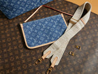 Blue monogram crossbody bag with wide white strap and gold zipper trim