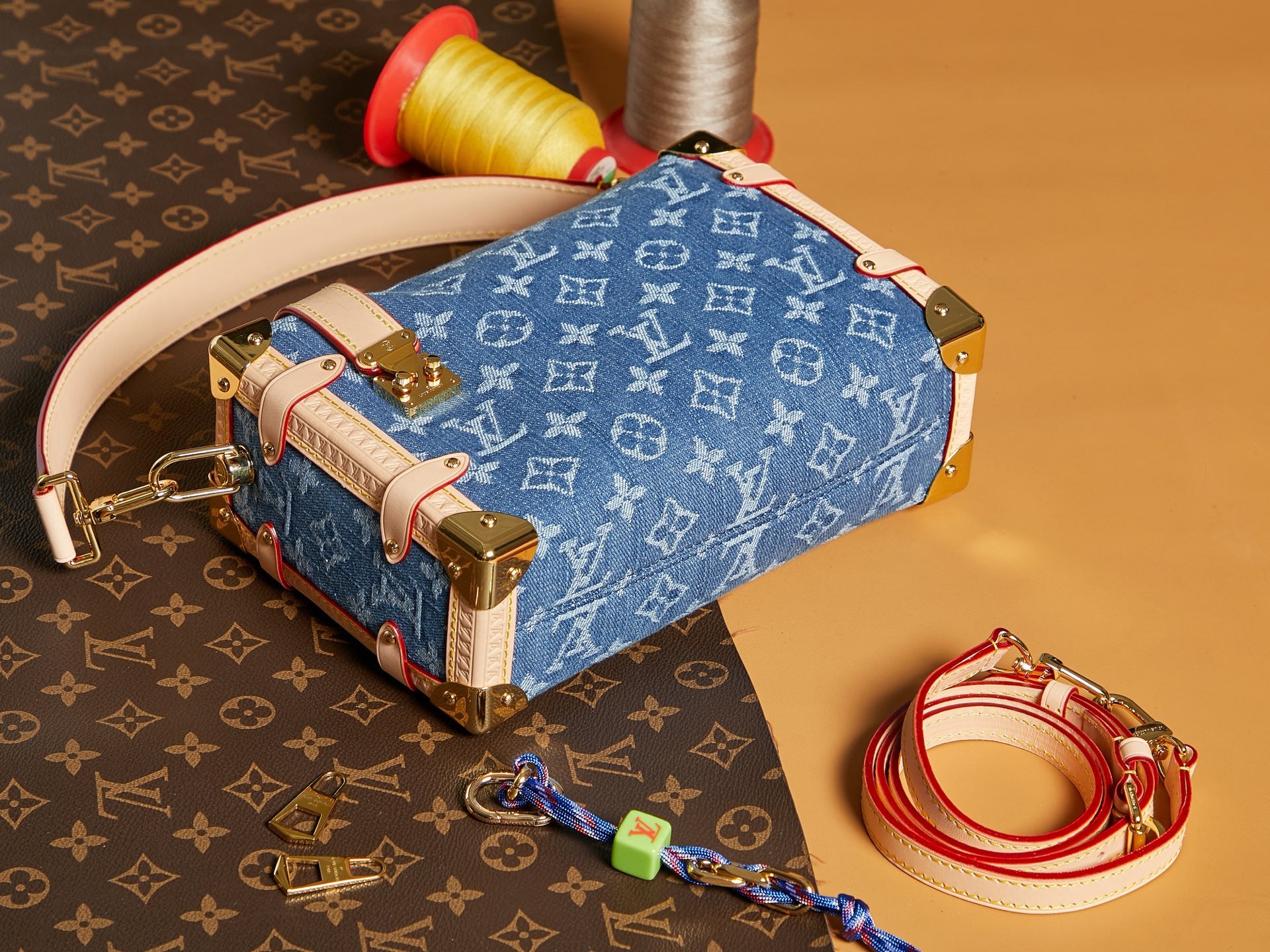 Louis Vuitton handbag with blue monogram canvas, tan leather top handle, and metal corners