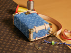 Louis Vuitton handbag with blue monogram canvas, tan leather straps, and gold hardware