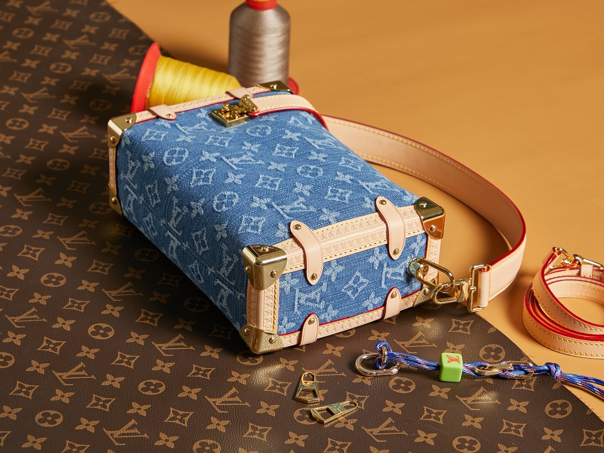 Louis Vuitton handbag with blue monogram canvas, tan leather straps, and gold hardware