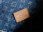 Louis Vuitton Paris leather label on blue denim with monogram texture