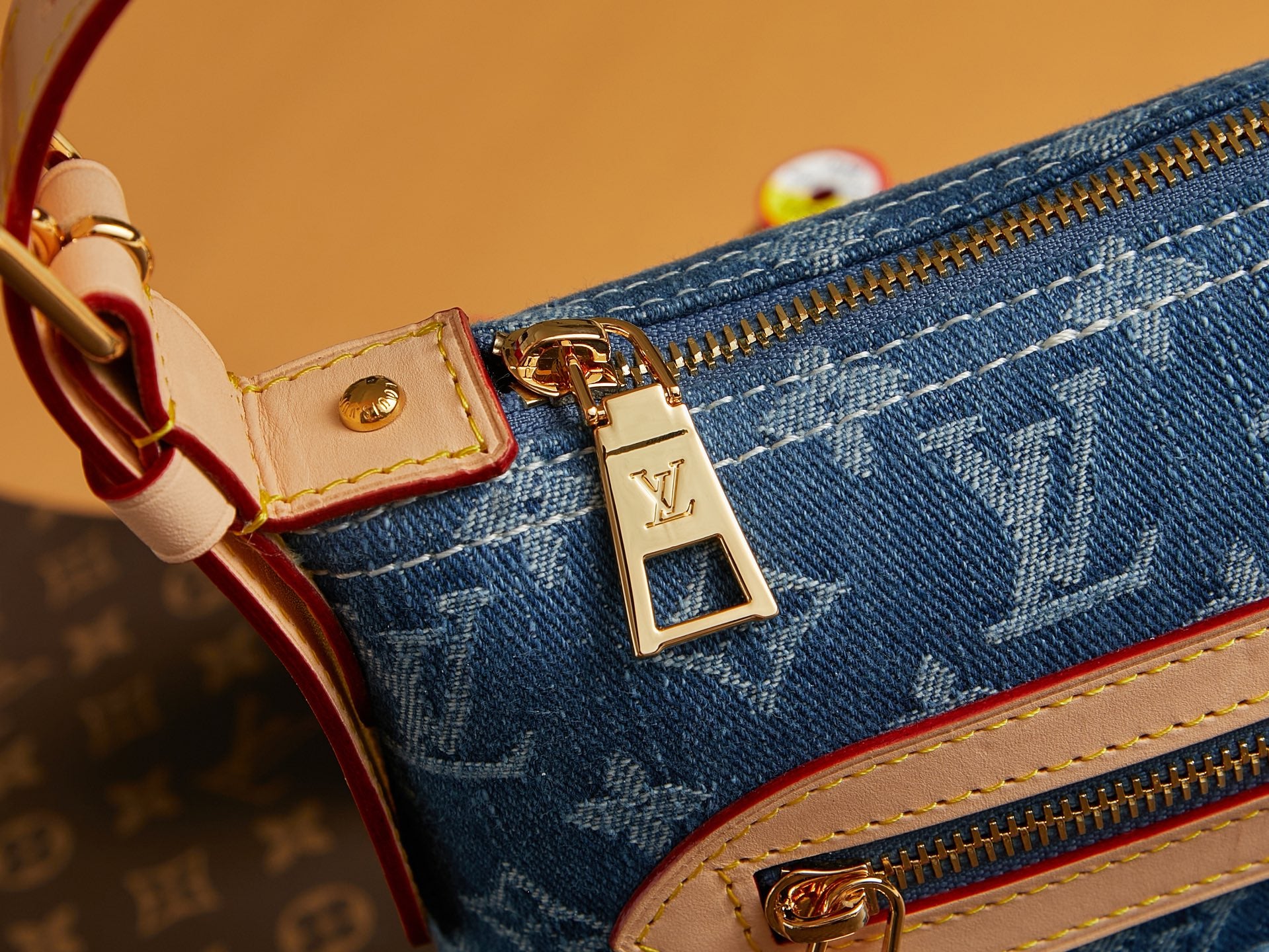 Blue denim side with zipper pull and gold-tone Louis Vuitton-style logo plaque