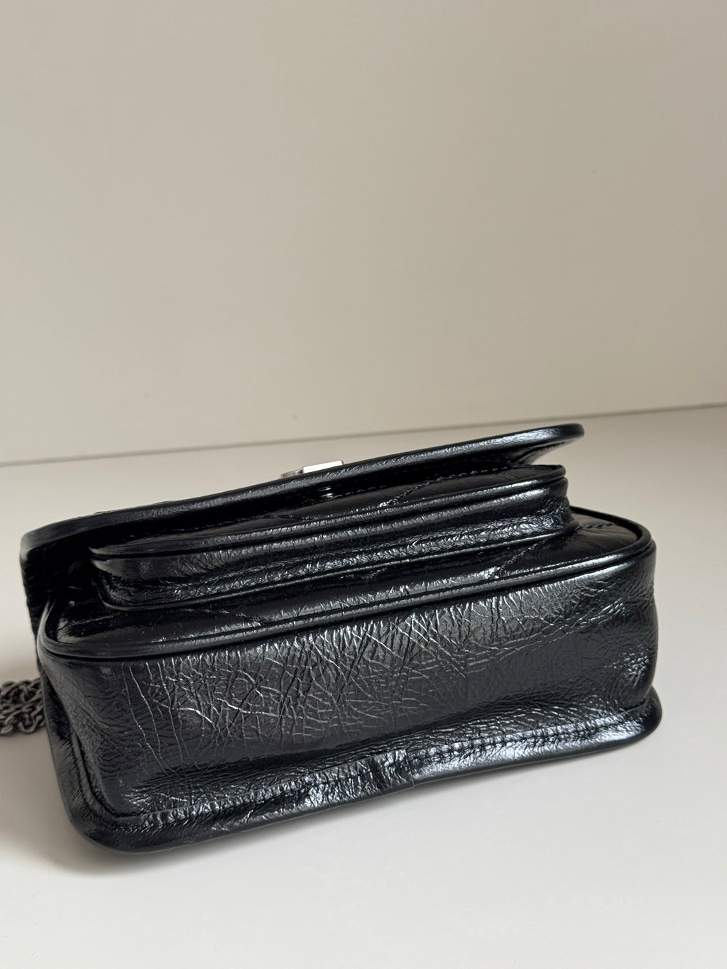 Black leather shoulder bag with stitched flap and top fold detailing