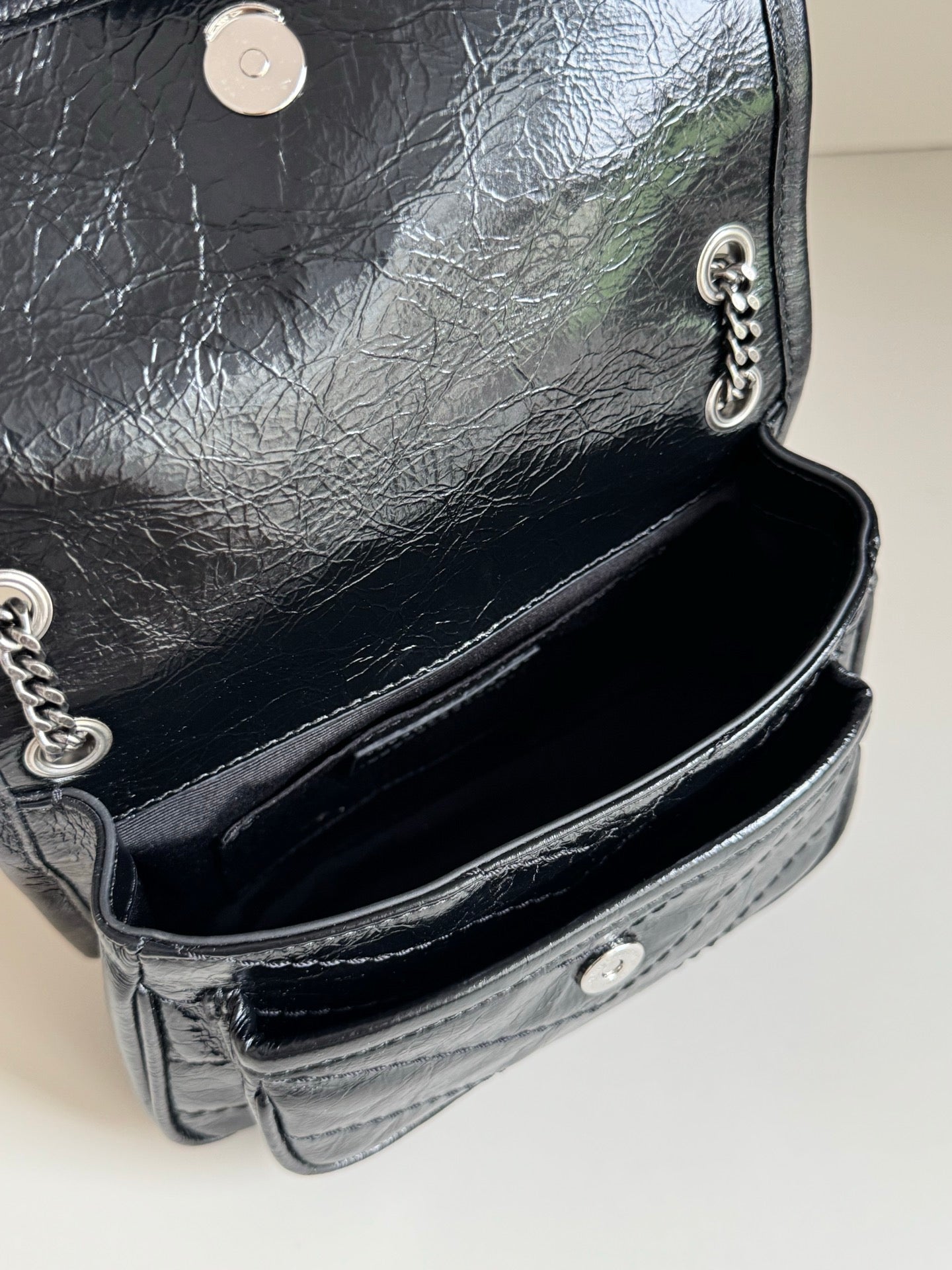 Black leather mini bag interior with chain strap and snap closure