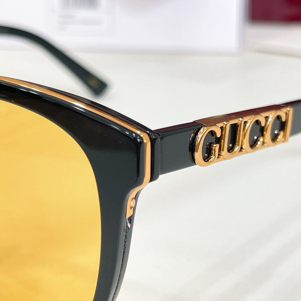 Black sunglasses arm with gold Gucci lettering and curved hinge