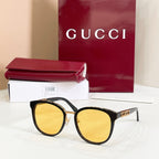 Sunglasses with black frames and yellow mirrored lenses, gold logo temple