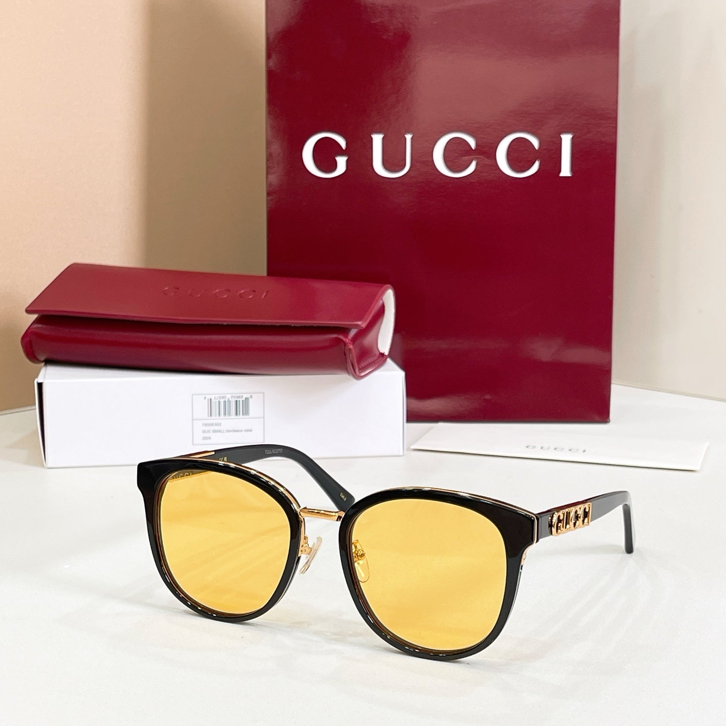 Sunglasses with black frames and yellow mirrored lenses, gold logo temple