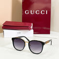 Gucci sunglasses with black frames and dark gray lenses, gold logo temples