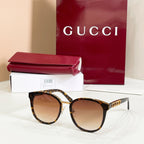 Sunglasses with tortoiseshell frames and brown tinted lenses, gold logo temple tips