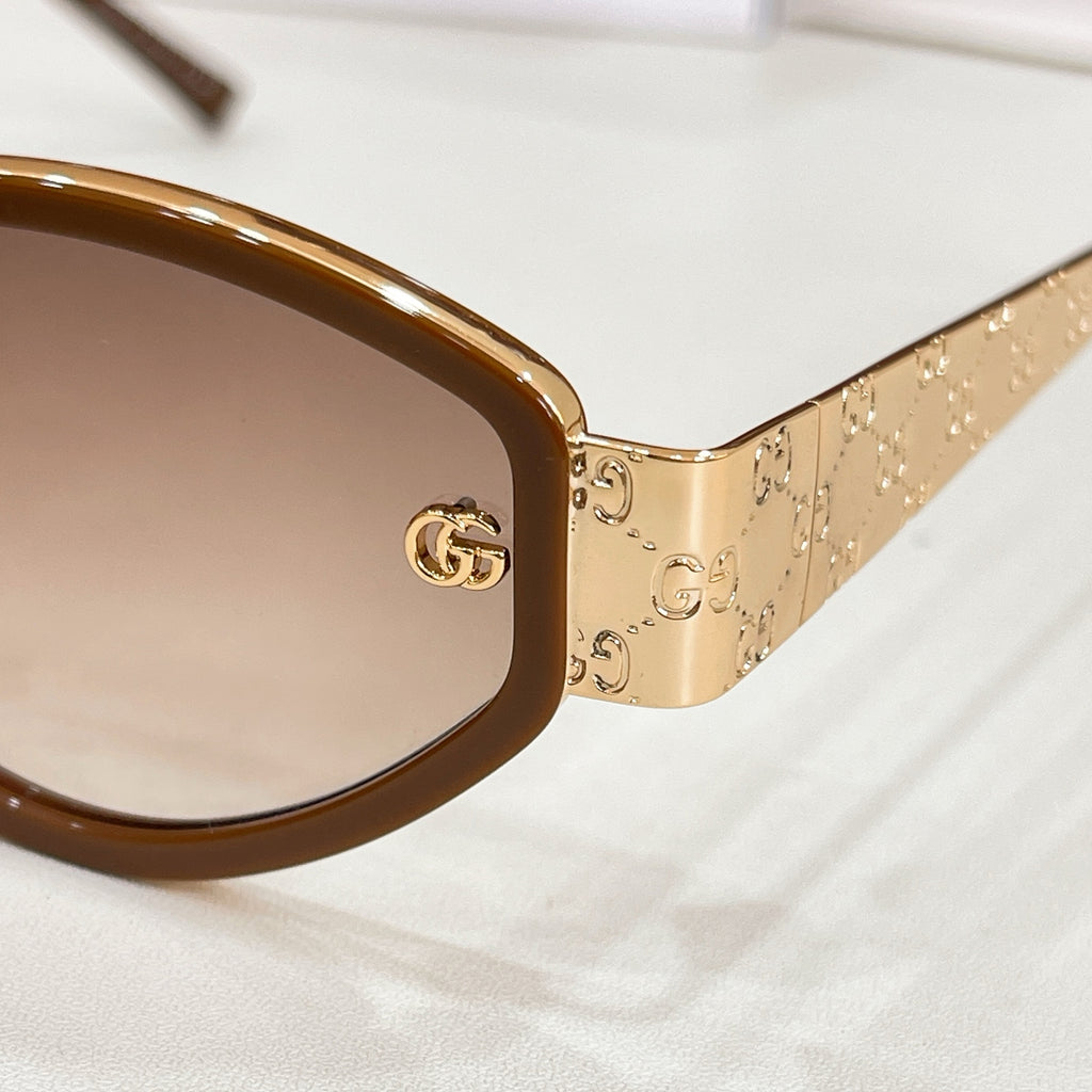 Sunglasses close-up: gold patterned temple with GG logo