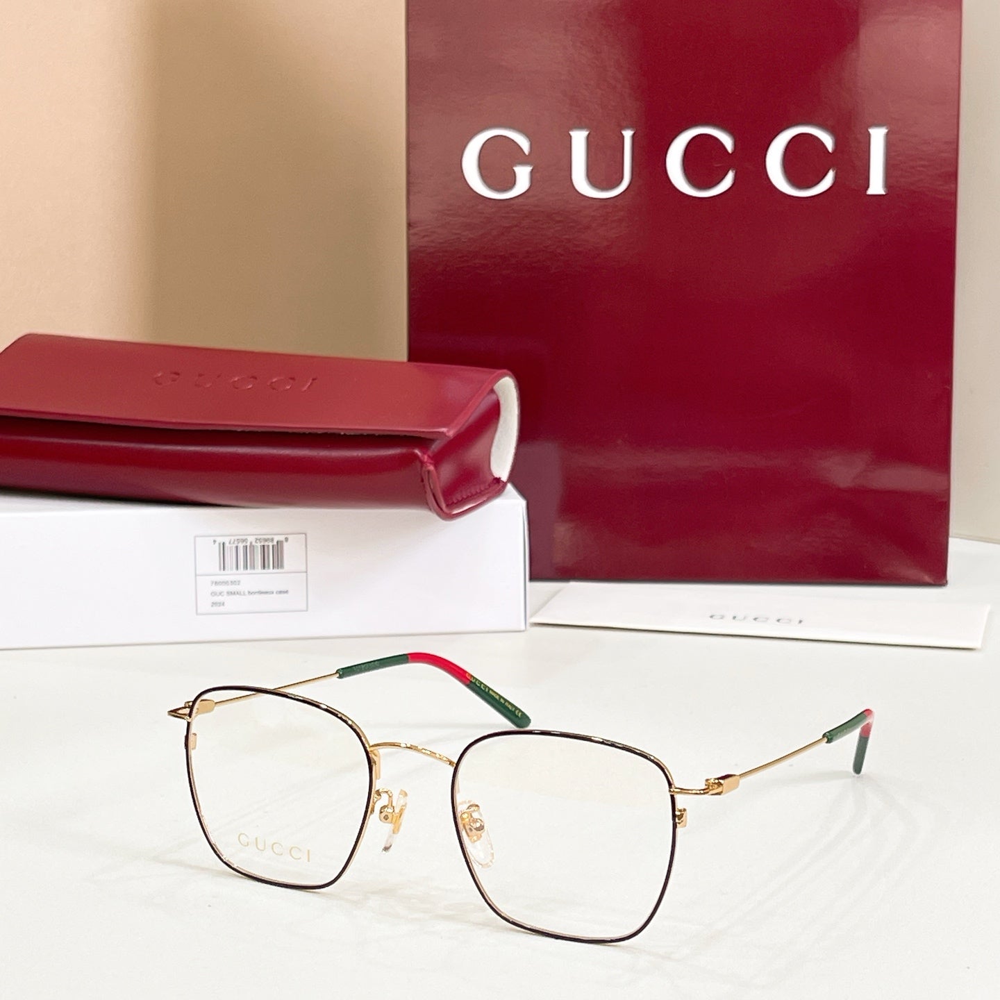 Rectangular eyeglasses with gold frame and green temple with red tip