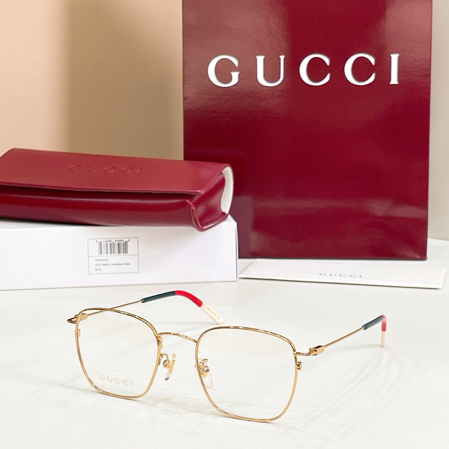 Rectangular eyeglasses with gold frame and red/green temple details
