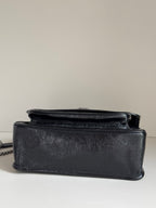 Saint Laurent black leather mini flap bag with top handle and compact shape