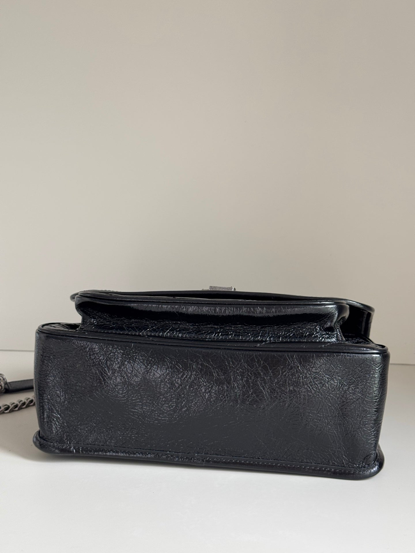 Saint Laurent black leather mini flap bag with top handle and compact shape