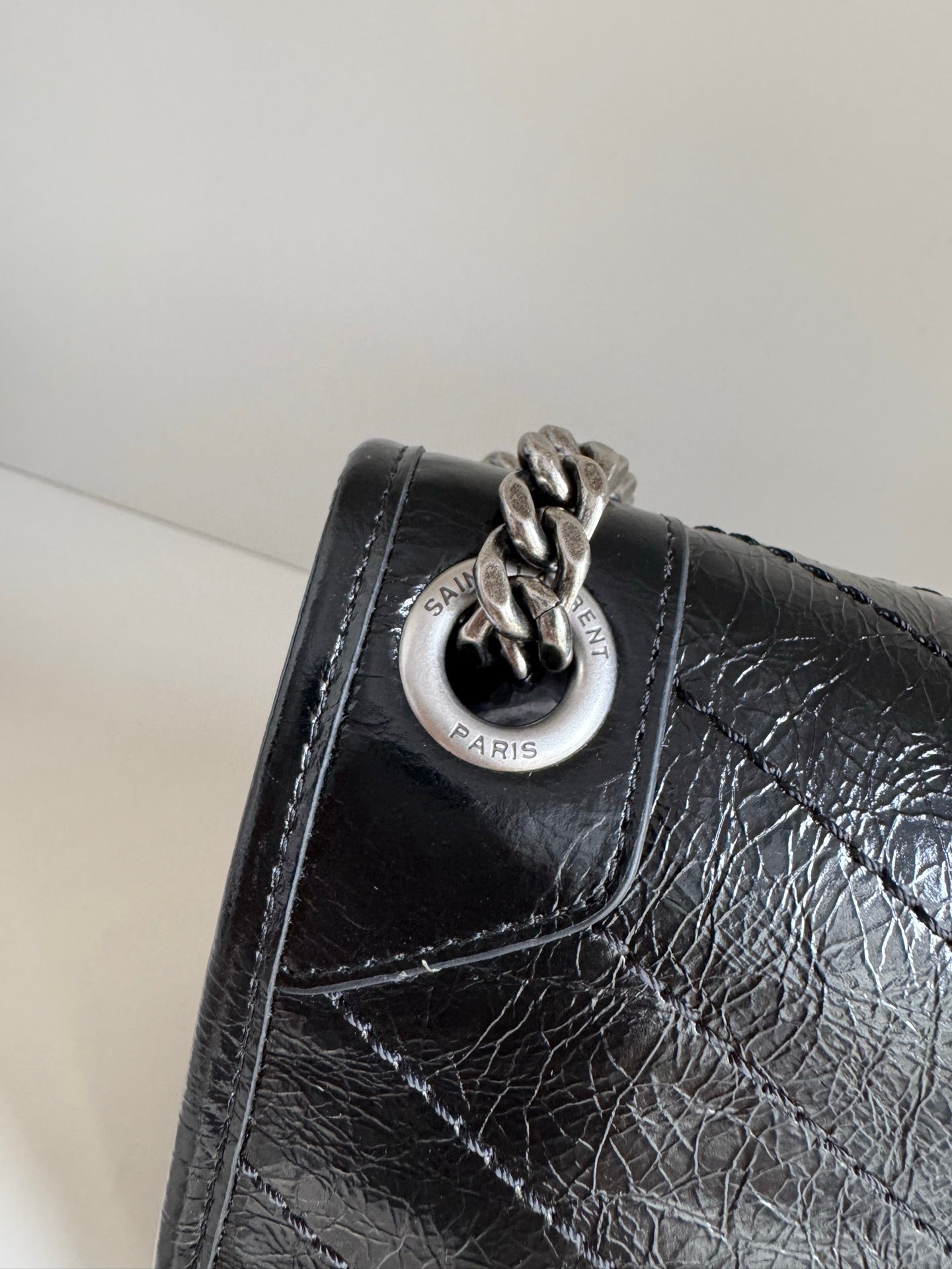 Saint Laurent black leather bag with circular logo plaque on flap