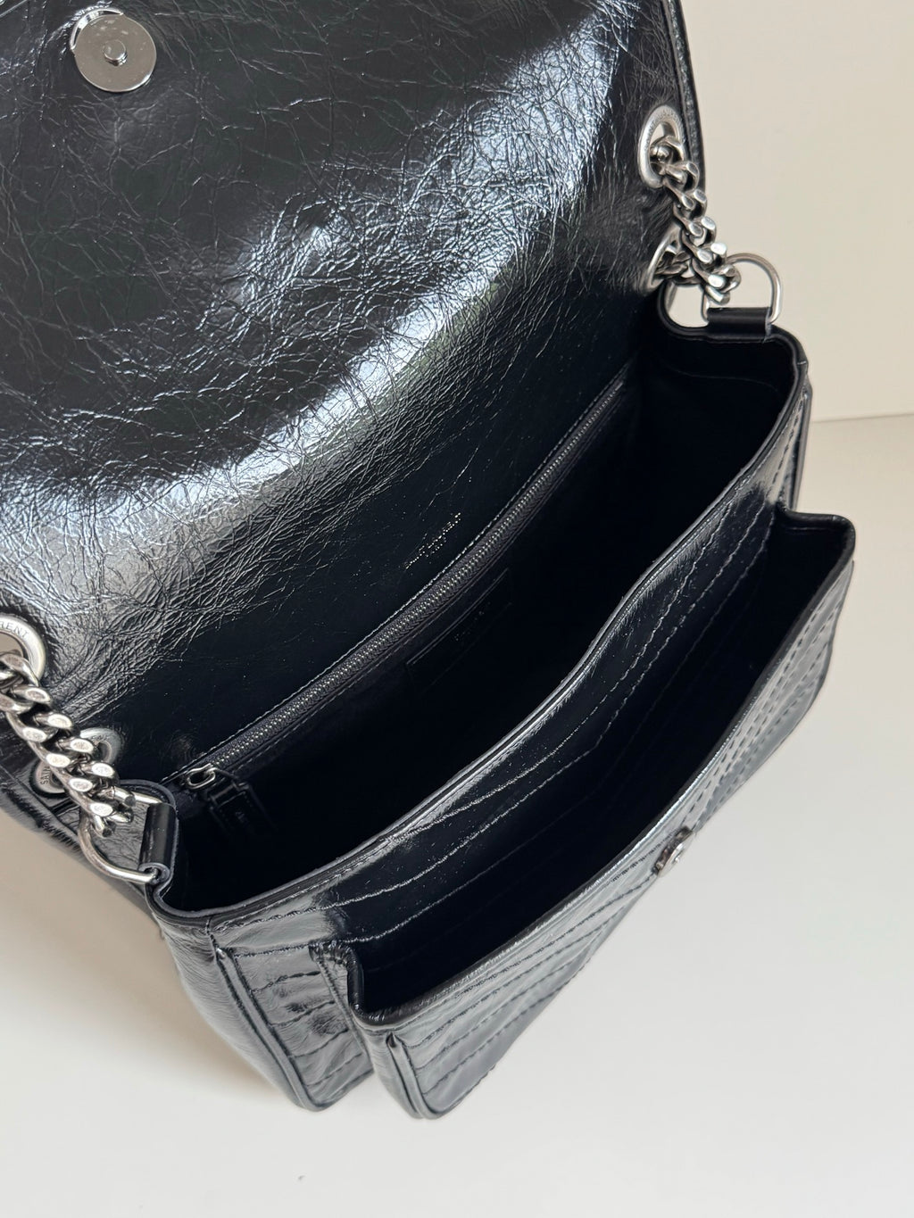 Saint Laurent black leather bag open view with chain strap and zipper closure